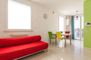 リミニにあるAppartamento Via Giumboの赤いソファ、テーブルと椅子が備わる客室です。