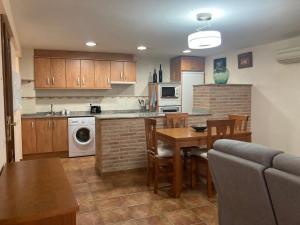 a kitchen and dining room with a table and a kitchen with a stove at Apartamento O'royo in Alquézar