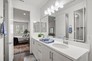 Un baño con lavabo y un espejo grande. en Gorgeous Family Home, Close to Frwys, Hospitals & Sports Arenas, Pets OK, en Orange 143 fotos más