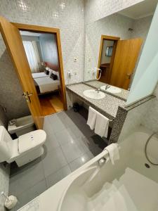 a bathroom with a tub and a toilet and a sink at Real Ferrol in Ferrol +63 photos