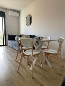 a living room with a table and chairs and a couch at Acogedor apartamento Vallparadís con parking in Terrassa
