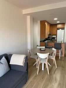 a living room with a couch and a table and a kitchen at Acogedor apartamento Vallparadís con parking in Terrassa