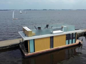 a boat sitting on a dock in the water at Houseboat Robbedoes in Offingawier