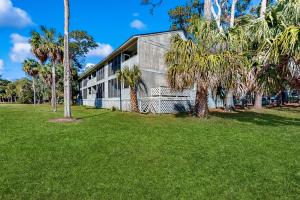 a building with palm trees in front of it at Fairway Watch - 295 in Edisto Beach