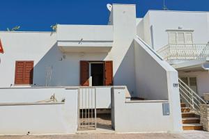 Una casa blanca con escaleras que conducen a ella. en Gallipoli Il mare in una stanza, en Lido Conchiglia