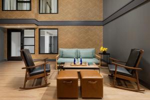 a living room with a couch and a table and chairs at Arcadian Hotel in Brookline