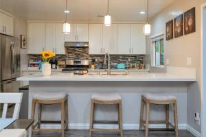 a kitchen with a large counter with stools in it at Modern Oasis for Families & Business, Pets OK, EV in Orange