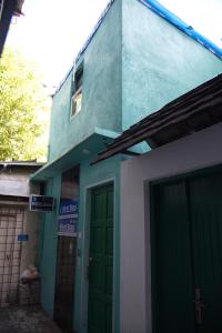 a building with a green door in front of it at Wind Stay in Male City