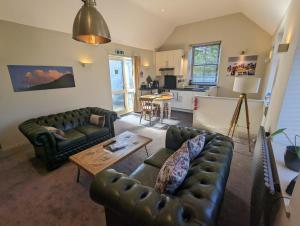 a living room with two couches and a table at Bandroom Cottage in Kirkby Stephen