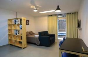 a bedroom with a bed and a couch and a chair at 01 Apartamento com area privativa, cozinha, máquina de lavar, vaga, Savassi in Belo Horizonte +10 photos