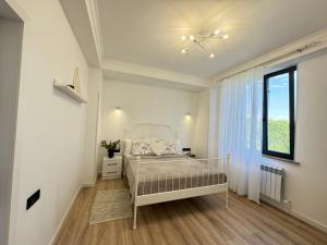 a white bedroom with a bed and a window at SamMar B&B in Ashtarak