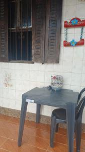 einem blauen Tisch und einem Stuhl vor einer Wand in der Unterkunft Casa com 2 quartos e 2 banheiros na Lagoa do Centro in São Pedro da Aldeia + 21 Fotos