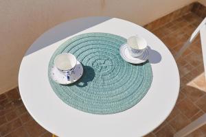 Una vista aérea de una mesa con dos tazas y una alfombra. en Gallipoli Il mare in una stanza, en Lido Conchiglia 57 fotos más