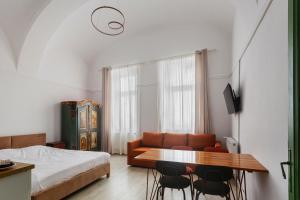 a bedroom with a couch and a table and chairs at AMS Cluj Central Stay Boutique in Cluj-Napoca