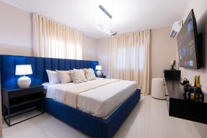 a bedroom with a large bed with a blue headboard at Modern 3BR! 9FL, King Bed! STI with Pool! Fast wifi! in Santiago de los Caballeros