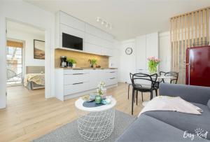 a living room with a couch and a table at Prestige Red z basenem in Pobierowo