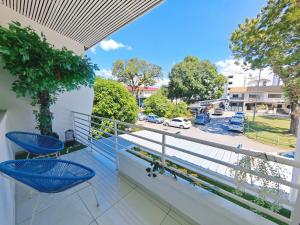 a balcony with blue chairs and a view of a street at 45GeorgeTown Multi Family corner lot free parking food convenience stores nearby in George Town