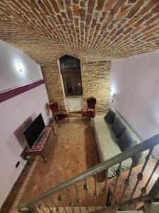a living room with a couch and a stone wall at Kiki House in Turin