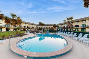 una piscina con sedie a sdraio e un resort di Oceanfront condo with direct beach access, shared pool, tennis a Fort Matanzas
