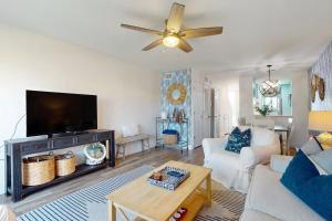 un soggiorno con un divano e una TV di Oceanfront condo with direct beach access, shared pool, tennis a Fort Matanzas