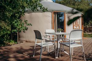 a table and chairs on a patio with a tent at Zatoka Bielika Glamping in Sielsko