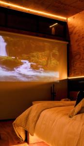 a bedroom with a bed with a painting on the wall at Cabanas Terrunyo - Cabana Bela in Urubici