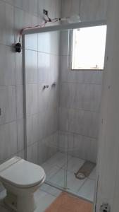 a bathroom with a shower with a toilet and a window at Hotel e Pousada Maresia & Sol in Água Boa
