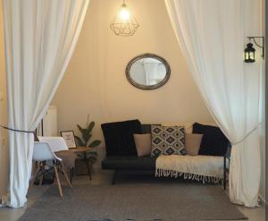 a living room with a couch and a mirror at Nicki's cozy apartment! in Ioannina +3 photos