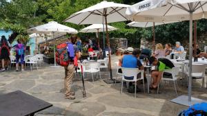 a group of people sitting at tables under umbrellas at Mercadoiro in Laje
