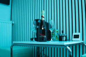 a bottle of wine and two glasses on a table at 13Pacate By ElProfesor in Bucharest