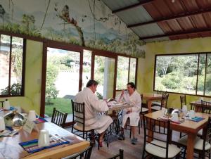 a group of people sitting at tables in a restaurant at Casa Augusto en El Refugio Spa Garden in Baños