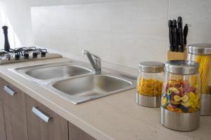 a kitchen counter with a sink and two containers of food at Il Piccolo Albero in Scardovari