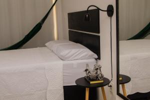 a bedroom with two beds and a table with a lamp at Flat vista para o mar in Cabedelo