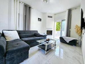 un soggiorno con divano blu e tavolo in vetro di Dream Luxury Suites & Apartment Pastida a Pastida
