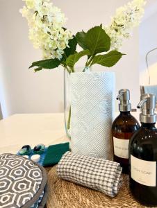 a table with two bottles of wine and a vase with flowers at Watersmeet Edge, Terrace, 2BR and 2BA, River Views, Parking in Lynmouth +19 photos