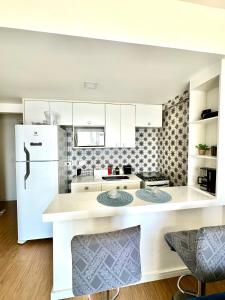 a kitchen with white cabinets and a white refrigerator at Apartamento Bela Vista Porto Real Resort in Mangaratiba +11 photos