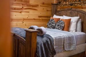 - une chambre avec un lit en bois et des oreillers dans l'établissement Sarah's Hideaway-Hot Tub Firepit & BBQ, à Stephens Gap