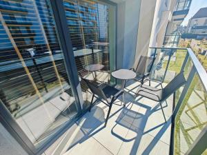 a balcony with a table and chairs on a building at Amber Coast Apartment Gdańsk in Gdańsk