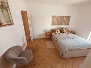 a bedroom with a bed and a chair at Amber Coast Apartment Gdańsk in Gdańsk