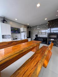 a kitchen with two wooden benches in a room at Casa Alter do Sol - 3 suites in Alter do Chao