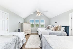 Un dormitorio con tres camas y un ventilador de techo. en Casa Playa, en Gulf Highlands