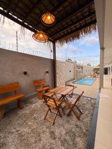 a patio with a table and chairs and a swimming pool at Casa Alter do Sol - 3 suites in Alter do Chao