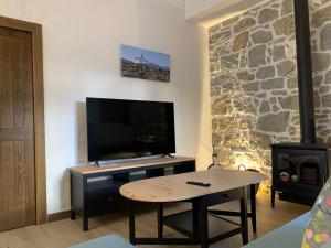 ein Wohnzimmer mit einem Tisch und einem Flachbildfernseher in der Unterkunft Venta Cerro del Águila in Ventas con Peña Aguilera