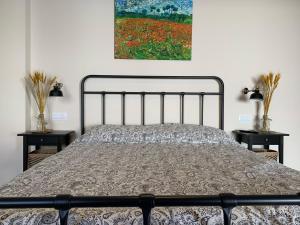 ein Schlafzimmer mit einem Bett mit zwei Tischen und einem Gemälde in der Unterkunft Venta Cerro del Águila in Ventas con Peña Aguilera + 32 Fotos