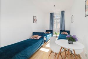 a living room with two beds and a table at Centrum 5 Łódź 7 Próchnika 21 in Łódź