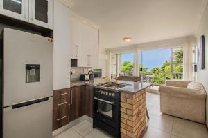 a kitchen with a stove top oven next to a window at North Beach Road in Umdloti