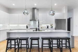 una cocina con una isla grande con 4 taburetes en Charlotte's Modern Luxe Home - Your Stylish Haven, en Charlotte