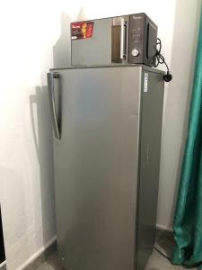 a microwave sitting on top of a refrigerator at Bliss Residence Bamburi Mwembeni in Mombasa +6 photos