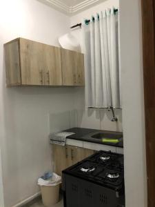 a kitchen with a stove and wooden cabinets at Bliss Residence Bamburi Mwembeni in Mombasa