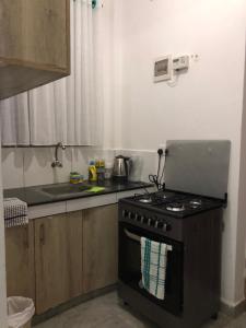 a kitchen with a stove and a sink at Bliss Residence Bamburi Mwembeni in Mombasa